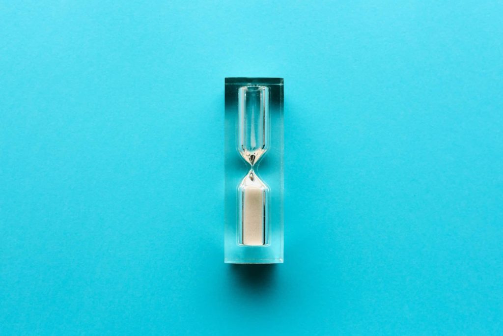 small-hourglass-on-blue-background